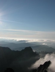 картинка рассвет в горах - солнышко встает из-за гор, среди облаков, для мобильного телефона